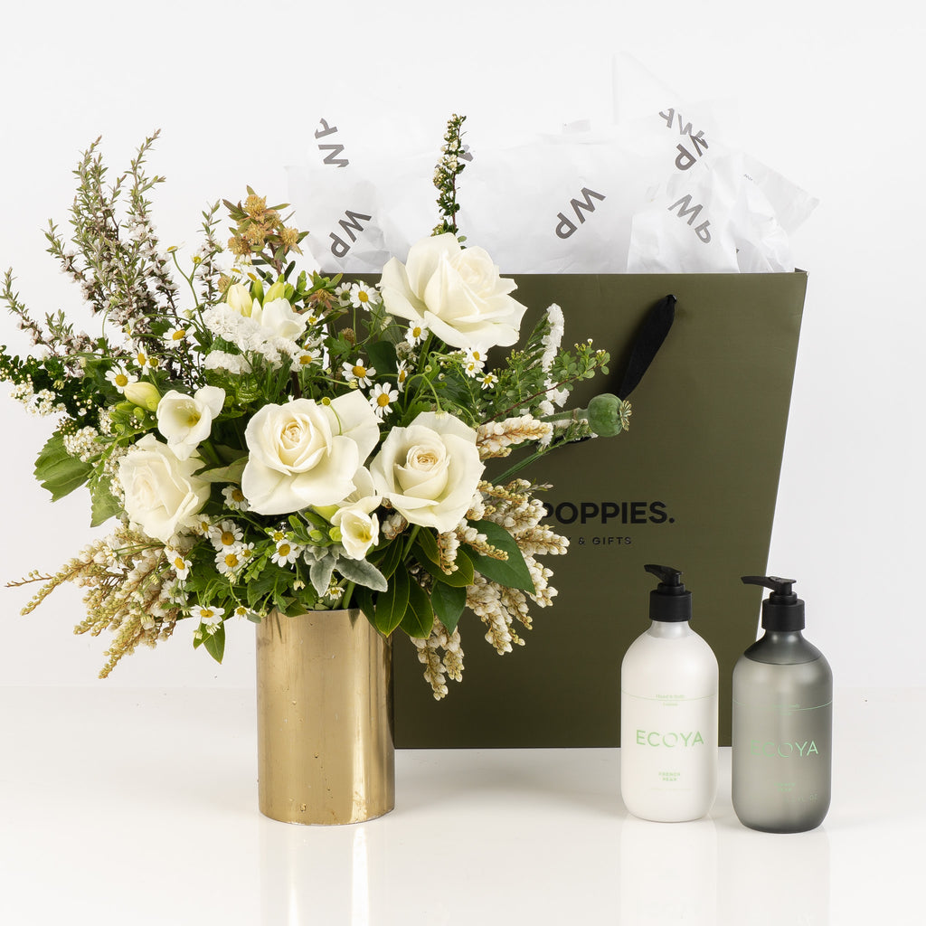 "New Home Gift Set" featuring a fresh white and green posy, Ecoya French Pear hand and body lotion, and hand and body wash. Presented in a premium Wild Poppies gift bag with satin ribbon and tissue paper, this elegant set brings warmth and luxury to a new home, perfect for creating a cozy and welcoming atmosphere.