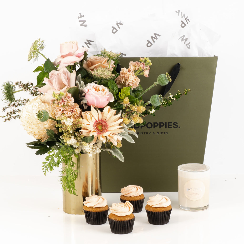 "She's Sweet" Gift Set featuring a fresh posy, four Petal cupcakes, and an Ecoya Vanilla and Tonka Bean Scented Candle. Elegantly presented in a premium Wild Poppies gift bag with tissue paper and satin ribbon, offering a charming and indulgent treat for any occasion.